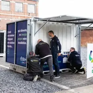 Équipe de techniciens Revolt Energy Green intervenant sur la maintenance et le raccordement d'un container hybride.