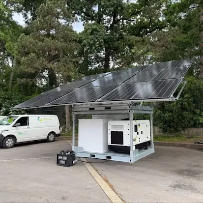 Unité hybride Revolt Energy Green intégrant panneaux solaires, stockage batterie et groupe électrogène de secours sur un parking.