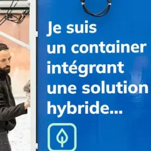 Gros plan sur un container d'énergie hybride Revolt Energy Green avec message pédagogique et technicien.